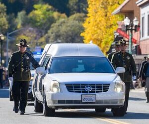 The honor guard walks with the hearse for fallen El Dorado County Sheriff s Deputy Brian Ishmael during his funeral procession in downtown Placerville on Tuesday, Nov. 5, 2019.