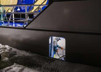 A fisherman working below deck onboard a trawler at night.