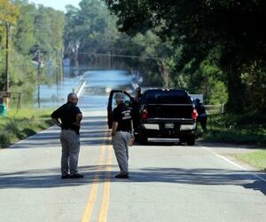 Responders congregate near where two people drowned the evening before when they were locked in a Horry County Sheriff's department transport van in Marion County, S.C. A deputy charged in the deaths ignored barricades and drove into rapidly rising floodwaters against advice from his supervisors and officials on the South Carolina highway, a prosecutor said Monday, May, 16, 2022.
