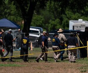 Investigators walk across a school yard at Robb Elementary School in Uvalde, Texas, Wednesday, May 25, 2022.