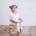 Child little girl sitting on a stack of books with glasses