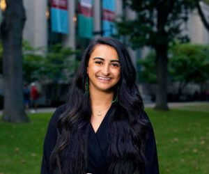 Head shot of Sondra Anton wearing a black dress and standing in Harvard Law School courtyard.