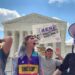 protesters shouting and holding signs in front of supreme court