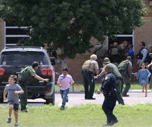 Law enforcement officials evacuate children from Robb Elementary School after a gunman killed 19 students and two teachers on March 24, 2022 in Uvalde, Texas.