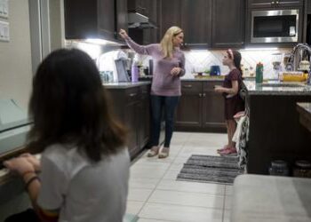 Danielle Miller prepares her two children for school in their home in Magnolia on Oct. 21, 2021.