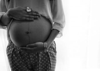 Woman holding her pregnant belly in B/W.