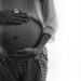 Woman holding her pregnant belly in B/W.