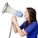 Pretty woman shouts into a megaphone, possibly protesting