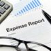 Close-up of an expense report with glasses and a calculator