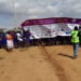 A parade of people hold a giant banner celebrating the Day of the African Child