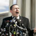Robert Schenck stands in front of a cluster of microphones at the Supreme Court Building in 2005