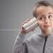 Boy on tin can phone listening to curious good news