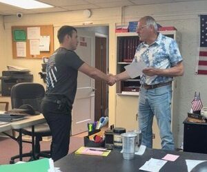 Sabin Ward, left, shakes hands with New Athens Mayor Joe Petro after being sworn-in.