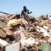 Colin Mapuranga sits on a pile of metal in a scrap yard near Hopley, a settlement outside Harare.