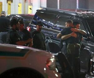 Police officers and other officials stand outside the Ryder Trauma Center after a Miami-Dade police officer was shot.
