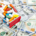 Full shopping cart with pills on background of dollar bills. Close up. Space for text.