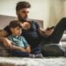 Dad and son watching movies together at home.