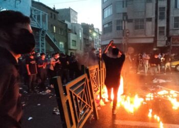 Protesters crowd behind a barrier in Tehran on 21 September.