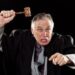 Furiously angry judge waves gavel, shouts and points threateningly