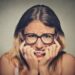 stressed anxious woman in glasses biting fingernails