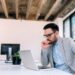 Serious businessman looking at laptop screen.