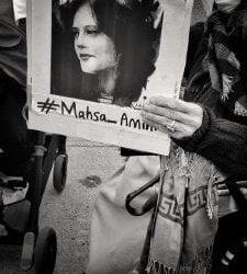 A protestor holds up a photo of Masha Amini