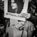 A protestor holds up a photo of Masha Amini