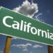 Green California Road Sign with Dramatic Clouds and Sky.