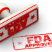 Red seal and imprint "FDA APPROVED" on white surface. FDA - Food and Drug Administration is a federal agency of the United States Department of Health and Human Services.