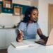 Young african american woman working from home and using a laptop
