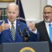 joe biden at lectern, gesturing with both hands, as miguel cardona looks on