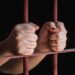 woman's hands in jail