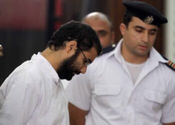 Alaa Abd el-Fattah (left) in court during his trial in Cairo, on 11 November 2014.