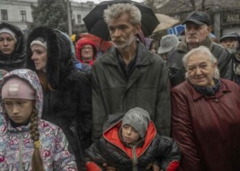 People attend an aid supply distribution in Kherson on Thursday.