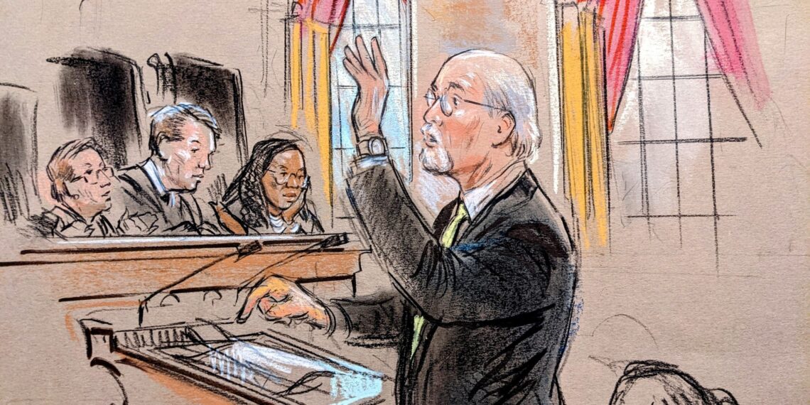 Man with glasses raises hand with wristwatch.