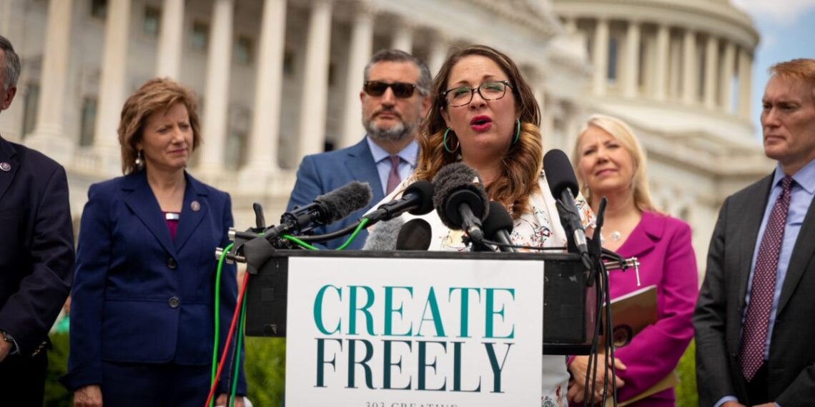 Woman speaking at podium in front of U.S. Capitol building
