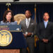 Woman speaking at podium with four people standing behind her.
