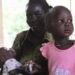 Mother, baby, and small girl dressed in pink
