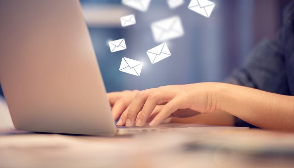 person sending emails on computer