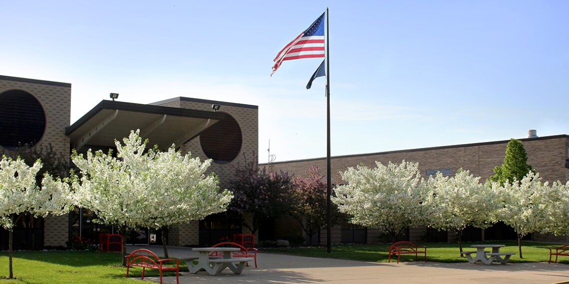 school building american flag and flowering trees on front lawn