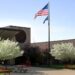 school building american flag and flowering trees on front lawn