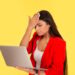 Regrets wrong doing while working online. Sad woman, slapping hand on head having duh moment while looking holding laptop computer