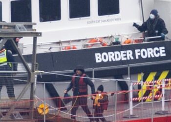 Migrants including women and children are removed from a Border Force vessel after being picked up in the Channel