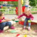 Conflict on the playground. Two kids fighting over a toy in the sandbox