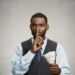 corrupt guy businessman holding dollar bill in hand showing shhh sign