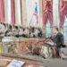 A wide shot of the court room. A man speaks from the lectern surrounded by a crowd as the justices speak from the bench.