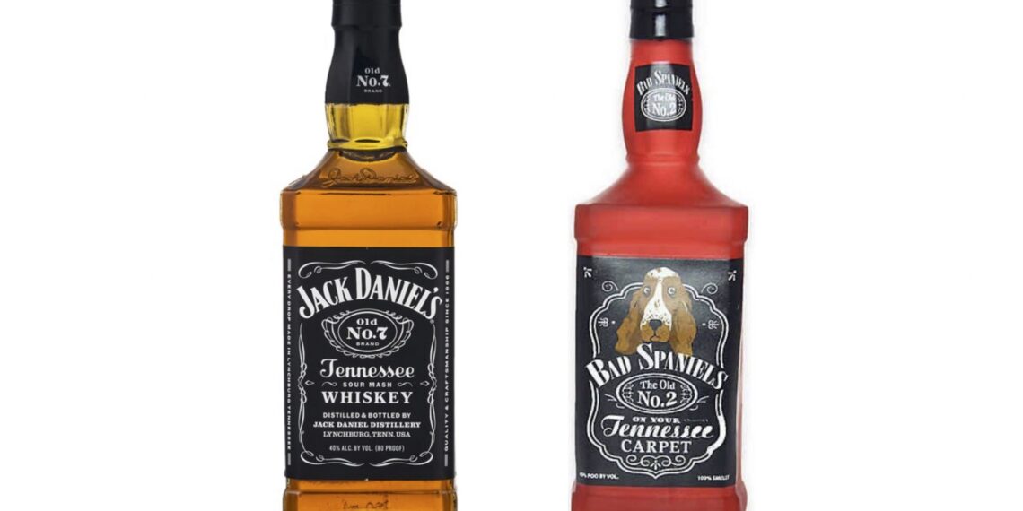 A bottle of Jack Daniel's whiskey next to a dog toy shaped to resemble the bottle