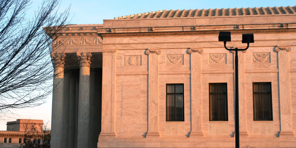 A side view of the Supreme Court building in pink sunlight.