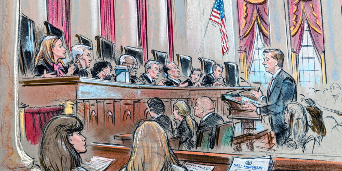 Man at lectern as audience and justices listen in.