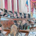 Man at lectern as audience and justices listen in.